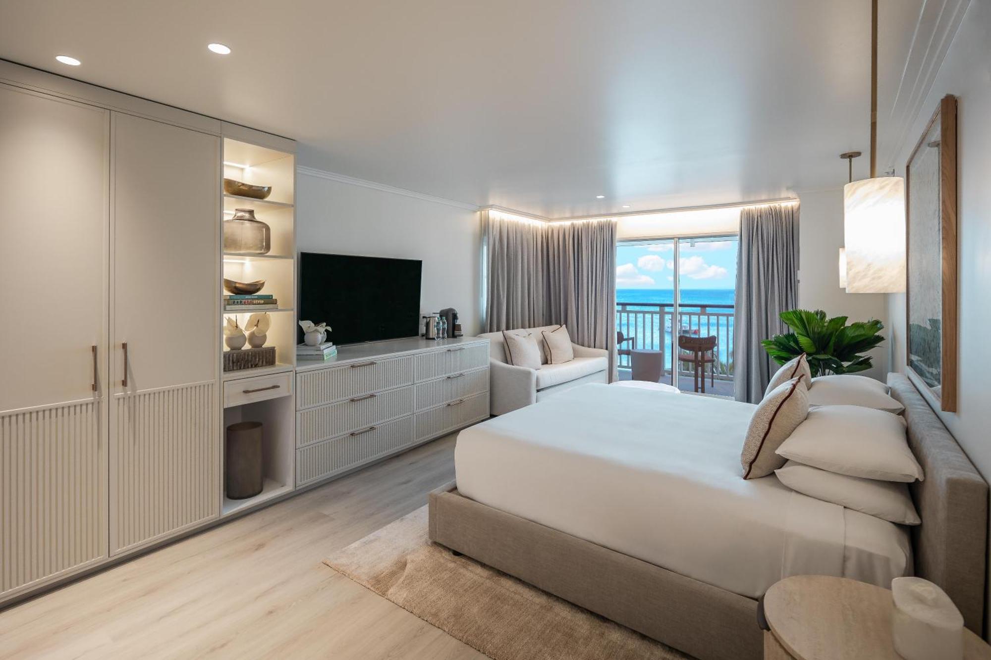 Habitación con cama extragrande, balcón y vistas parciales al mar